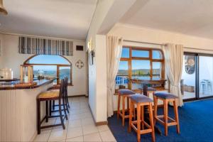 a kitchen and living room with a view of the ocean at Pamosoro Pegomo Villa - Luxurious Knysna Views! in Knysna