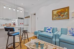 ピレウスにあるh2h NODEhome, fine, tech, smART apt piraeus 1' metroの青いソファとキッチンのあるリビングルーム