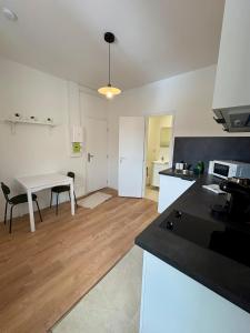a kitchen and dining room with a table and a dining room at Green 3 - Roubaix Gare in Roubaix +6 photos