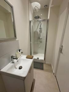 a white bathroom with a shower and a sink at Green 3 - Roubaix Gare in Roubaix