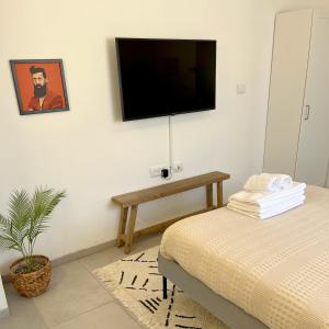 a bedroom with a bed and a tv on the wall at ארץ מדבר - יחידת אירוח בבאר אורה in Beʼer Ora