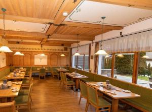 a dining room with wooden tables and chairs at Hotel Binderhäusl in Berchtesgaden