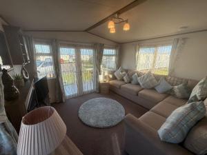 a living room with a couch and a tv at Skegness Retreats The Grange F59 in Ingoldmells