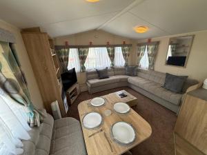 a living room with a couch and a table at Skegness Retreats The Grange F59 in Ingoldmells