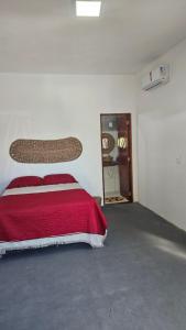 ein Schlafzimmer mit einem Bett mit einer roten Decke in der Unterkunft Casa de Praia em Icaraizinho Anahí Lodge in Amontada