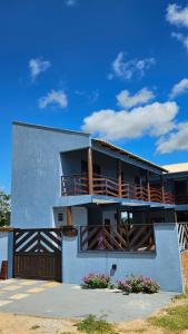 ein Haus mit einem Balkon mit Blumen darauf in der Unterkunft Casa de Praia em Icaraizinho Anahí Lodge in Amontada