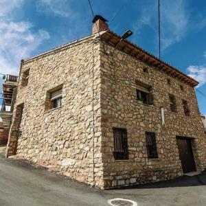 een groot bakstenen gebouw met ramen aan een straat bij DonPepo Guesthouse in Torres de Albarracín