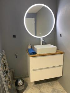 a bathroom with a sink and a mirror on a dresser at Le Numéro 2 in Ornans