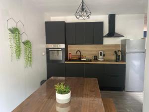 a kitchen with black cabinets and a wooden table at Le Numéro 2 in Ornans