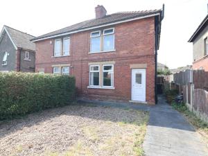 ein rotes Backsteinhaus mit einer weißen Tür in der Unterkunft Spacious 3 Bedroom With Garden and Free Parking with fast Wi-fi in Rawmarsh