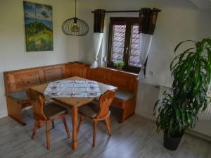 a dining room with a table and chairs and a plant at Ferienwohnung Osterberg in Unterthingau