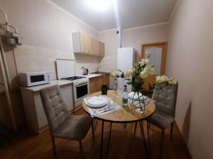 eine kleine Küche mit einem Tisch und Stühlen, die mit Blumen geschmückt sind in der Unterkunft Двокімнатна квартира на Садовому з балконом in Shcherbani