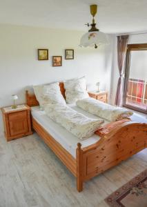 a bedroom with a wooden bed with pillows on it at Ferienwohnung Osterberg in Unterthingau +2 photos