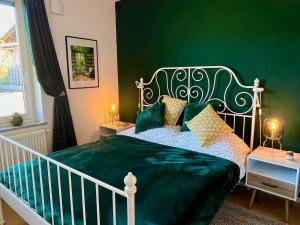 een groene slaapkamer met een bed met een groene muur bij Mountain Vista Apartment in Bled