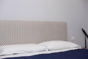 una cama con cabecero gris y blanco en Luce -Modern Suite Apartment in Florence, en Florencia