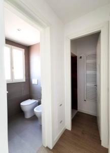 Un baño blanco con inodoro y ventana. en Luce -Modern Suite Apartment in Florence, en Florencia 8 fotos más