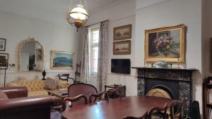 een woonkamer met een tafel en een open haard bij Stonehurst Guest House in Kaapstad