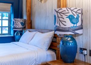 1 dormitorio con 1 cama y un jarrón azul sobre una mesa en Wheatsheaf Inn, Bar Hill, en Onneley