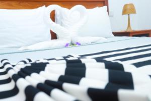a bed with white sheets and white pillows at Menai Bay Escape in Mkunguni