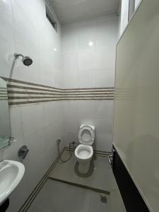 a bathroom with a toilet and a sink at Sapo Guest House in Berastagi