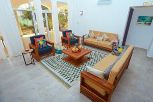 a living room with couches and chairs and a table at Menai Bay Escape in Mkunguni