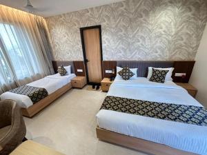 a hotel room with two beds and a couch at lotusinn in Bānswāra