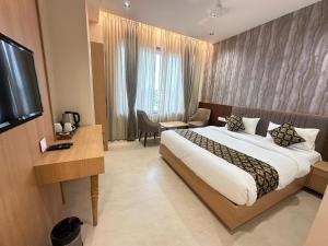 a hotel room with a bed and a television at lotusinn in Bānswāra