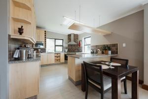 a kitchen with a wooden table and a dining room at Whale Away Guest House in Hermanus