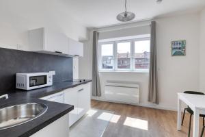 a kitchen with a sink and a microwave at Green 3 - Roubaix Gare in Roubaix