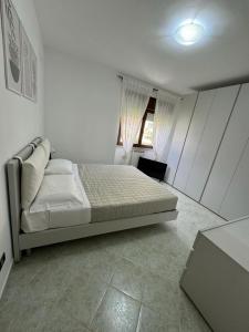 a white bedroom with a bed and a window at LIKE HOME in Norma