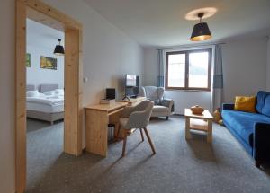 a living room with a couch and a desk with a computer at Rezort Gothal Apartmány a Penzióny in Donovaly