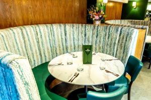 una mesa en un restaurante con sillas y vasos en Wheatsheaf Inn, Bar Hill, en Onneley