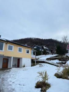 une maison avec de la neige devant elle dans l'établissement Arctic View House - near Cable Car & Arctic Cathedral, à Tromsø