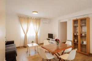 a living room with a dining room table and chairs at En el Corazón de Sevilla in Seville