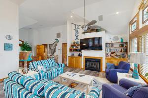 a living room with blue couches and a fireplace at WV09 Play Time in Waves