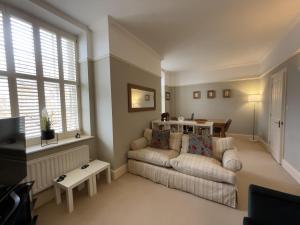 ein Wohnzimmer mit einer Couch und einem Fenster in der Unterkunft The Manor Retreat in Oxford