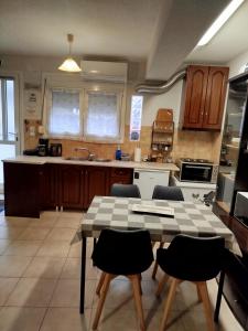 a kitchen with a table and chairs in it at City Nikis Apartment in Volos +16 photos
