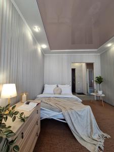 ein großes Schlafzimmer mit einem großen Bett und einer Kommode in der Unterkunft Однокімнатна квартира на 9 поверсі на Садовому in Shcherbani