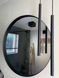 a round mirror hanging on a wall in a living room at Chambre d Amis in Lokeren +18 photos