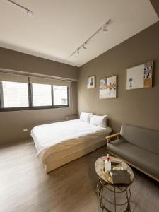 een slaapkamer met een groot bed en een bank bij meimo文旅 in Taichung