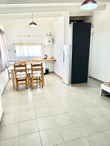 a kitchen with a table and chairs and a refrigerator at Casa una habitación, 4 personas, zona parque in Necochea