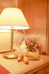 a table with a lamp and ears of corn on it at Brauereigasthof Gut Forsting in Pfaffing