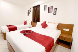 2 bedden in een hotelkamer met rode accenten bij Hotel Arctic Gold in Cochin +12 foto's