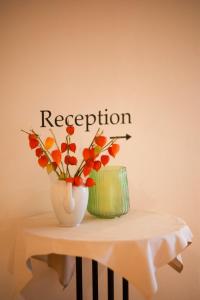 a vase of flowers on a table with the word reception at Brauereigasthof Gut Forsting in Pfaffing +2 photos