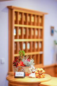 a table with a plant and a bowl of fruit at Brauereigasthof Gut Forsting in Pfaffing