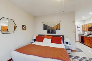 a bedroom with a large bed with orange pillows at Main Street Station #1210 in Breckenridge +19 photos