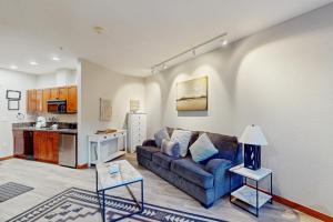a living room with a couch and a kitchen at Main Street Station #1210 in Breckenridge