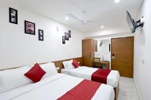 2 bedden in een kamer met witte en rode kussens bij Hotel Arctic Gold in Cochin
