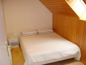 een kleine slaapkamer met een wit bed in een kamer bij Maison Les Volets Bleus Binic in Lantic