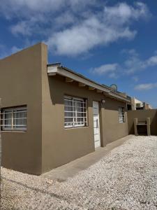 a brown house with a driveway in front of it at Casa una habitación, 4 personas, zona parque in Necochea